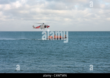 L'hélicoptère des garde-côtes et la pratique de la RNLI et afficher leurs techniques de sauvetage au large de Pagham Beach West Sussex UK Banque D'Images