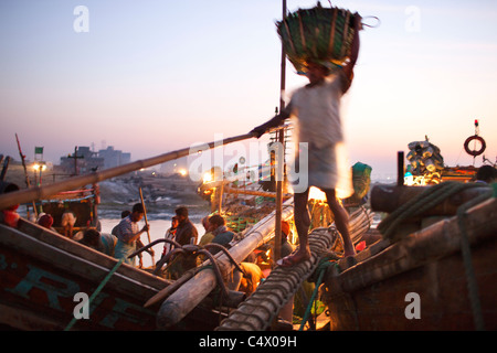 Le déchargement du poisson au lever du soleil à Ghat la pêche, Chittagong, Bangladesh Banque D'Images