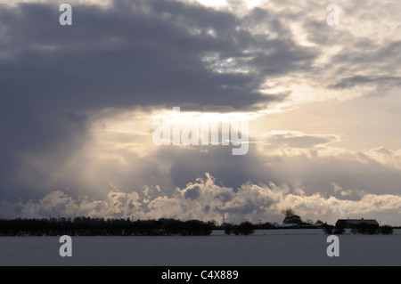 La lumière du soleil à travers les nuages de rupture sur les terres agricoles, un jour d'hiver, Holderness, East Yorkshire, Angleterre