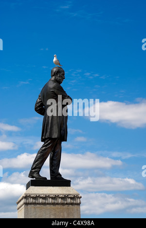 Une mouette se repose sur la tête d'une statue en bronze. Banque D'Images