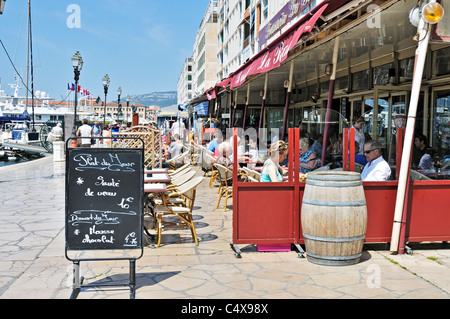 Les promeneurs flâner le long des quais entre les bateaux de plaisance d'un côté et boutiques cafés et restaurants sur l'autre, de Toulon Banque D'Images