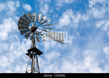 Jusqu'à lors d'un métal à l'ancienne, le pompage de l'eau moulin contre un ciel bleu nuageux. Banque D'Images