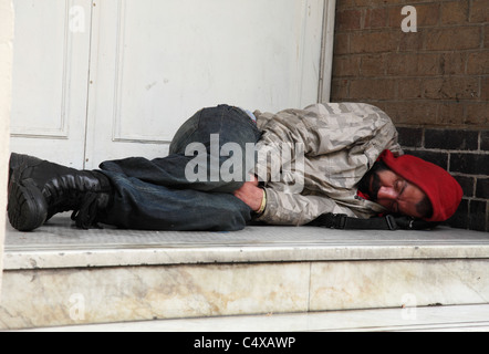 Un sans-abri à la rue d'une porte dans une ville du Royaume-Uni. Banque D'Images