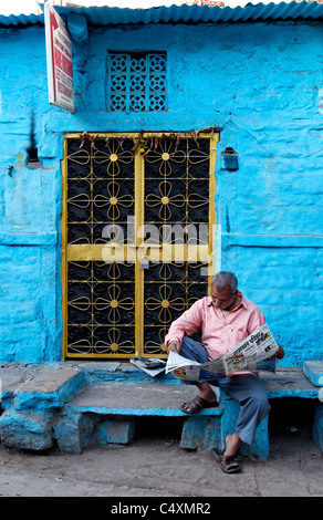 L'homme de lire le journal dans une rue de Jodhpur Banque D'Images