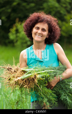 Jeune agriculteur femme tenant une gerbe d'aneth fraîchement cueilli Banque D'Images