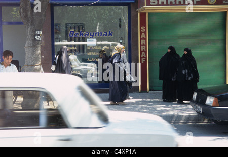 Scène de rue avec circulation en mouvement et les femmes portant des burkas, Konya, Anatolie centrale, Turquie. Banque D'Images