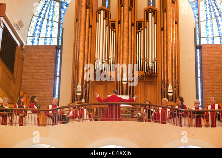 Chorale de l'église conduit Directeur en chanson devant des tuyaux de l'orgue à tuyaux pendant le dimanche de Pâques à l'église luthérienne de service Banque D'Images