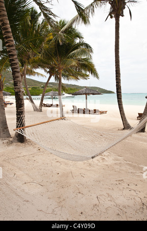 Chaises de plage et parasols au Canouan Estate Resort & Villas à Carenage Bay, île de Canouan, Saint-Vincent-et-les Grenadines. Banque D'Images