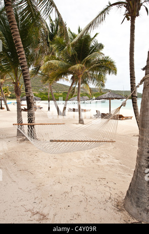 Chaises de plage et parasols au Canouan Estate Resort & Villas à Carenage Bay, île de Canouan, Saint-Vincent-et-les Grenadines. Banque D'Images