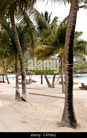 Chaises de plage et parasols au Canouan Estate Resort & Villas à Carenage Bay, île de Canouan, Saint-Vincent-et-les Grenadines. Banque D'Images