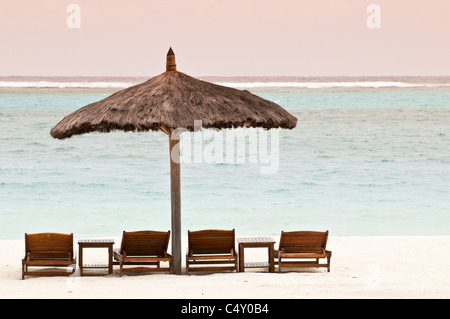 Chaises de plage et parasols au Canouan Estate Resort & Villas à Carenage Bay, île de Canouan, Saint-Vincent-et-les Grenadines. Banque D'Images