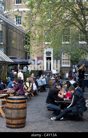 Les gens boire et manger dans le café en plein air de l'ambiance Bar, Brick Lane, London, England, UK Banque D'Images