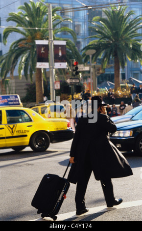 San Francisco, Californie. Le rabbin sur téléphone cellulaire traverse dans la circulation sur occupation Union square intersection © Bob Kreisel Banque D'Images