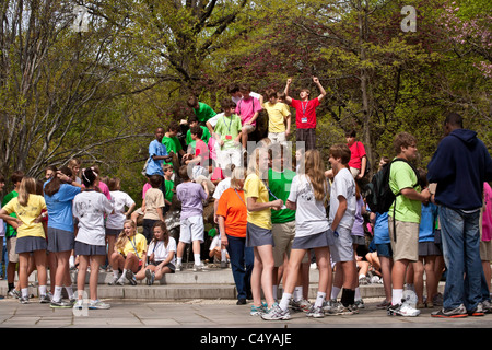 Voyage de classe du secondaire les élèves couvrant sur Alice Wonderland Statue, Central Park, NYC Banque D'Images