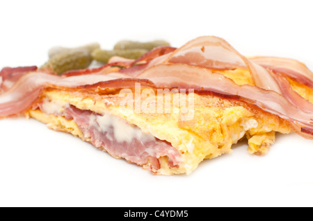 Oeufs brouillés, avec fromage, bacon et prosciuto sur une plaque blanche. Un repas avec un bon nombre de calories. Banque D'Images