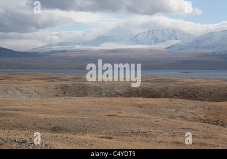 En bordure du lac Bayan Olgii Aimag dans la région de Tsengekhayrkhan, contre sommets enneigés et les nuages bas dans les montagnes de l'Altaï Banque D'Images