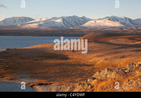 En bordure du lac Bayan Olgii Aimag dans la région de Tsengekhayrkhan, contre sommets enneigés et les nuages bas dans les montagnes de l'Altaï Banque D'Images