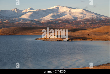 En bordure du lac Bayan Olgii Aimag dans la région de Tsengekhayrkhan, contre sommets enneigés et les nuages bas dans les montagnes de l'Altaï Banque D'Images