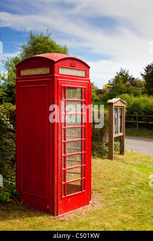 La traditionnelle boîte de téléphone rouge et village noticeboard, England, UK Banque D'Images