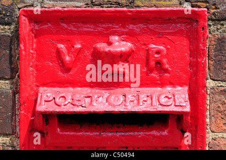 Une photo en gros plan d'un victorien rouge fait British Royal Mail lettre/post box intégré dans un mur de briques. Banque D'Images