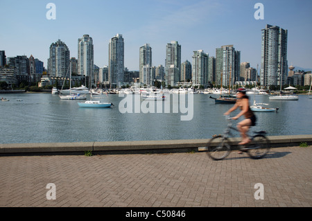 Une femme à vélo sur la piste cyclable de la digue à Vancouver, Canada Banque D'Images