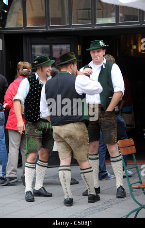 Des hommes à l'extérieur fumer lederhosen bavaroise Hofbrauhaus Munich Bavaria Allemagne Munchen Deutschland Banque D'Images