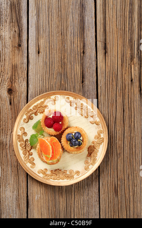 Pâte feuilletée remplie de crème anglaise surmontée de coquilles de fruits frais Banque D'Images