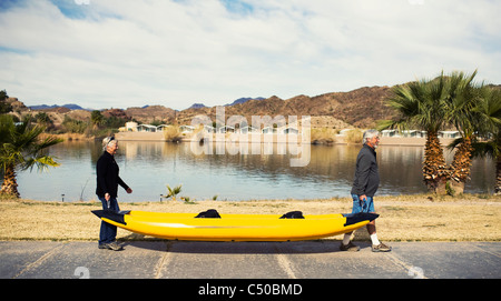 Young couple carrying kayak Banque D'Images