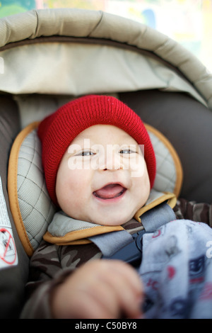 Grinning caucasian baby in car seat Banque D'Images