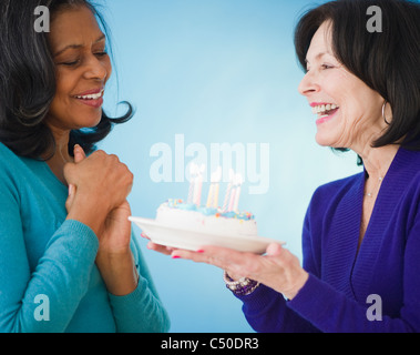 Femme surprenant ami avec gâteau d'anniversaire Banque D'Images