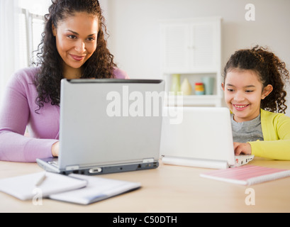Mère et fille à l'aide d'ordinateurs portatifs ensemble Banque D'Images