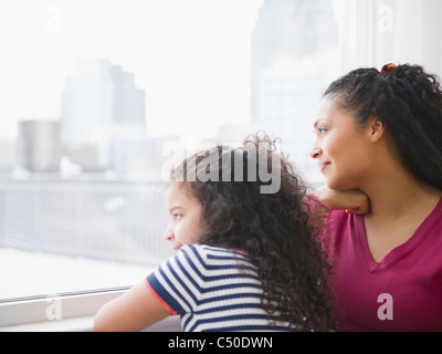 Mère et fille looking out window Banque D'Images