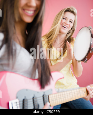 Les jeunes filles jouent de la guitare et tambourin Banque D'Images