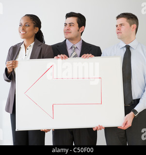 Business people holding whiteboard et flèche Banque D'Images