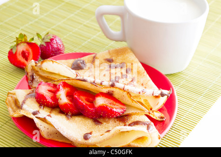 Petit-déjeuner tasse de lait avec du lait et des crêpes aux fraises Banque D'Images