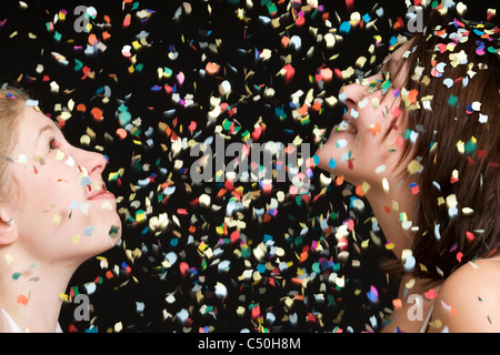 Deux jeunes femmes dans une pluie de confettis Banque D'Images