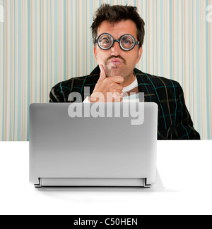 Lunettes Nerd pensive man expression stupide de penser une solution informatique ordinateur portable Banque D'Images