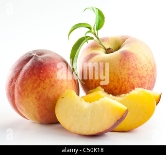 Fruits pêche mûre avec des feuilles et des tranches sur fond blanc. Banque D'Images