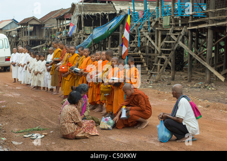 Moines et nonnes bouddhistes sur leur matin l'aumône ronde, Kompong Klang, sur la rive du lac Tonle Sap, près de Siem Reap, Cambodge Banque D'Images