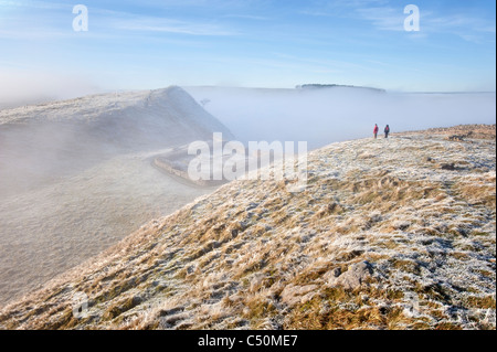 Deux marcheurs regarder vers le bas sur un milecastle sur mur d'Hadrien, l'un des paysages d'hiver spectaculaire dans le Northumberland National Park Banque D'Images