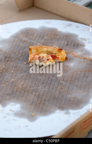 Une boîte de pizza vide avec un débris d'un morceau qui reste dans le récipient en carton jusqu'graissé. Banque D'Images