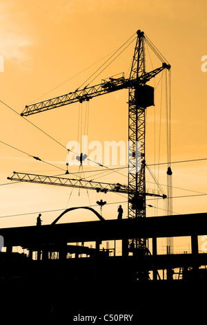 Deux grues de construction et les travailleurs de la construction sur place Banque D'Images