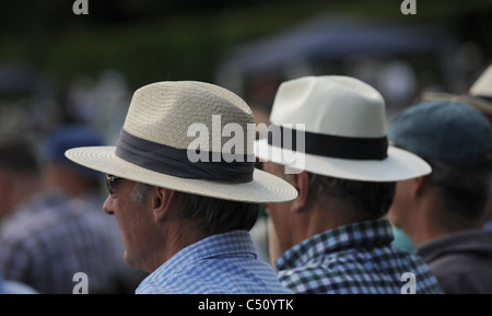 Les hommes portant des chapeaux panama bénéficiant d''un verre en regardant un match de cricket UK Banque D'Images