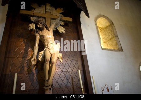 Une statue de Jésus Christ crucifié lui montre l'extension de sa main dans une église dans le chemin de Saint-Jacques de Compostelle, Galice, Espagne Banque D'Images