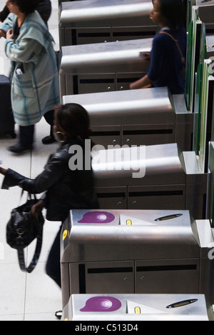 Les gens passant par les tourniquets dans subway station Banque D'Images