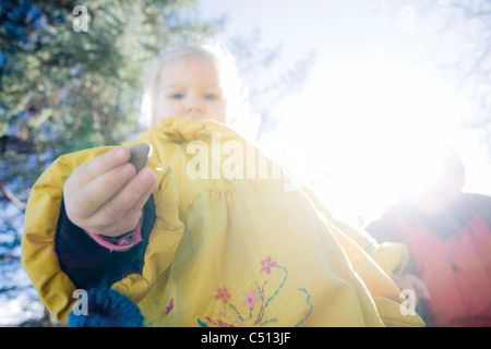 Baby Girl caillou dans part curieusement, low angle view Banque D'Images