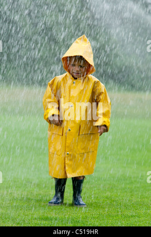 Portrait de jeune garçon portant imperméable jaune Banque D'Images