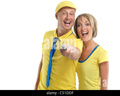 Jeune couple avec un rire de la télécommande du téléviseur. Isolé sur fond blanc. Banque D'Images