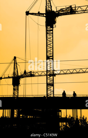 Deux grues de construction et les travailleurs de la construction sur place Banque D'Images