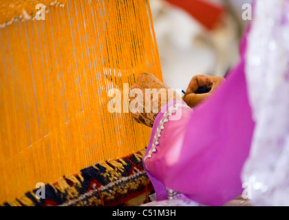 Close up de mains d'une femme marocaine à l'aide d'un métier à tisser à la main Banque D'Images